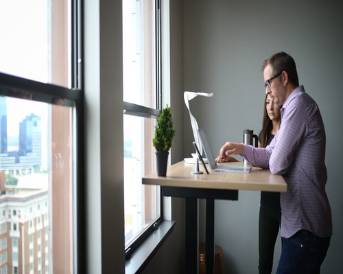 Person stretching gently near an office window